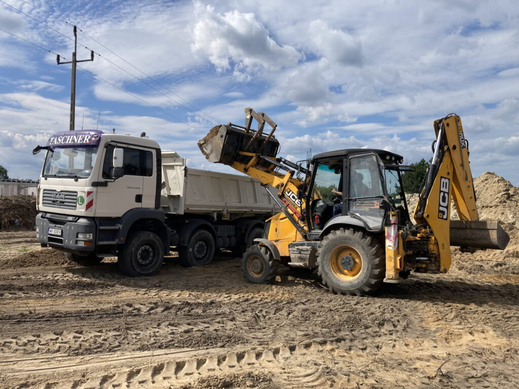 Koparko-ładowarka JCB podczas załadunku wywrotki – Radom